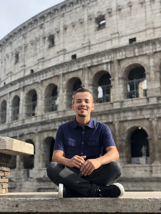 Viajante sentado em frente ao Coliseu, em Roma